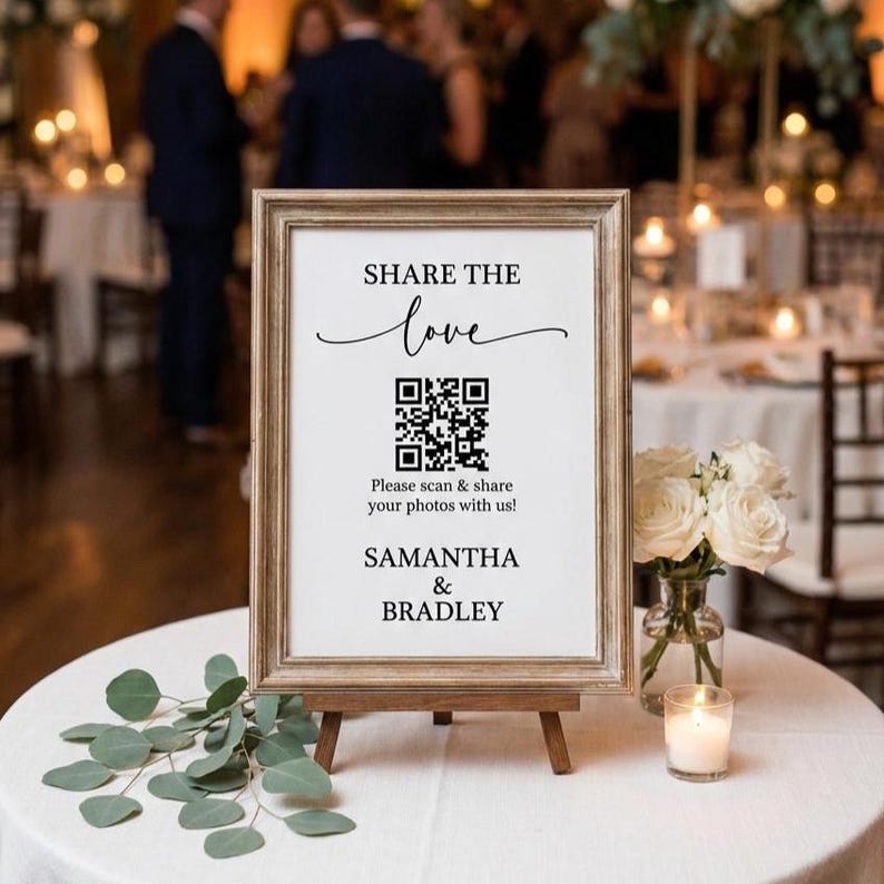 May include: A framed sign with the text "SHARE THE love" and a QR code, displayed on a wooden easel. The sign also includes the names "SAMANTHA & BRADLEY" and the phrase "Please scan & share your photos with us!"