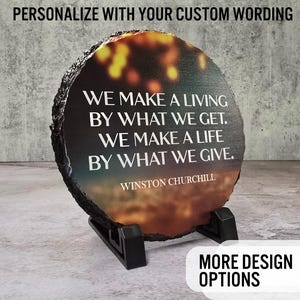 May include: A round, dark gray stone coaster with a colorful sunset image and a white inspirational quote by Winston Churchill: "We make a living by what we get. We make a life by what we give."