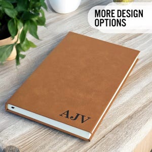 May include: A brown leather-bound journal with the initials "AJV" embossed on the front cover.