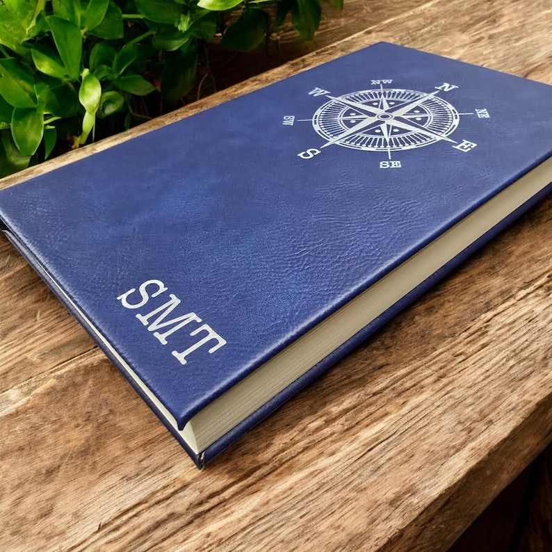 May include: A blue leather-bound journal with a compass design and the initials "LWS" embossed on the cover.