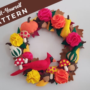 Könnte beinhalten: Ein Filz-Adventskranz mit einem roten Kardinal, Kürbissen, Kürbissen, Pilzen und Herbstblättern. Der Kranz ist mit gelbem, orangefarbenem, rotem und grünem Filz verziert. Der Text "Sew-It-Yourself PATTERN" ist in der oberen linken Ecke des Bildes sichtbar.