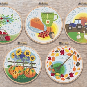 Puede incluir: Cinco aros de bordado con diferentes diseños de temática otoñal. Los aros presentan un manzano rojo, un campo de calabazas, una tarta y una taza de té, un tractor y gansos, y un rastrillo y hojas.