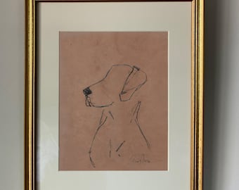 Op de afbeelding: Een ingelijste zwart-witte lijntekening van een hondenkop op een lichtbruine achtergrond. De tekening is gesigneerd met "Emily Rose".