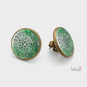 Könnte beinhalten: Ein Paar runde Ohrringe in Bronze mit einem grünen und schwarzen Mandala-Muster.