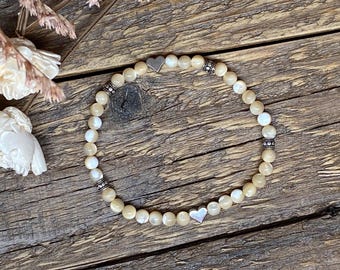 Pulsera elástica de cuentas de concha natural con detalles plateados