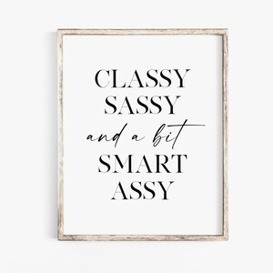 Op de afbeelding: Een zwart-witte printbare wandkunstprint met de tekst "CLASSY SASSY and a bit SMART ASSY".