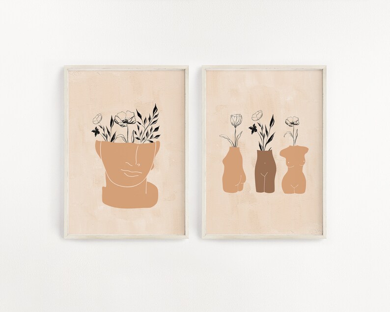 Pu&ograve; includere: Due stampe d'arte minimaliste con sfondo beige. La prima stampa presenta una testa umana stilizzata con fiori che crescono dalla parte superiore. La seconda stampa presenta tre figure umane stilizzate con fiori che crescono dalla parte superiore.