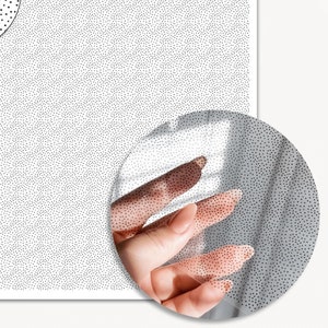 May include: A white sheet of paper covered in a pattern of tiny black dots. The paper is slightly wrinkled and has a shadow cast on it.