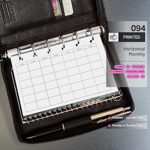 May include: Black leather Filofax organizer with a printed horizontal monthly calendar. The calendar is undated and can start on Monday or Sunday. A black pen rests below the calendar. The organizer includes a pocket for cards and the text "094 PRINTED".