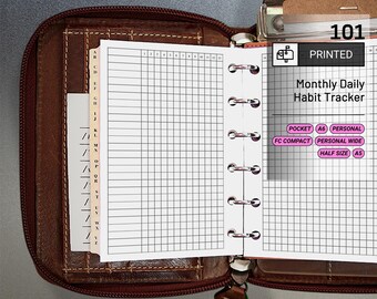 May include: Open brown leather planner with a zipper, revealing a printed "Monthly Daily Habit Tracker" on white paper. The tracker is designed with a grid for daily entries. Includes size options: Pocket, A6, Personal, FC Compact, Personal Wide, and Half Size (A5).