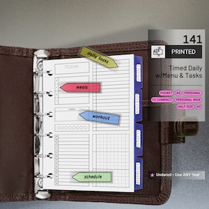 May include: A brown leather planner with a printed daily task sheet. The sheet includes sections for meals, workouts, and schedule, with colorful tabs for finance, wellness, and peanuts. The planner is undated and can be used any year.