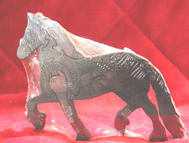 May include: A dark brown wooden puzzle shaped like a standing horse. The figure is composed of several interlocking wooden pieces that fit together to form the silhouette of a horse with a textured mane, tail, and defined legs in a side profile.