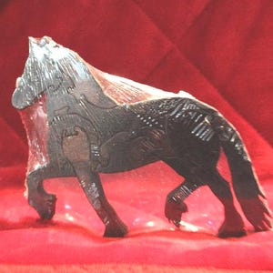 May include: A dark brown wooden horse figurine crafted from interlocking puzzle pieces. The horse is depicted in a standing position with a textured mane and tail, showing visible seams where the individual wooden components fit together.