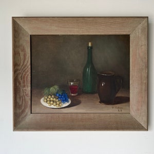 May include: A framed still life painting of a green glass bottle, a brown ceramic pitcher, a glass of red wine, and a plate of grapes. The painting is signed "P. Osber 68".