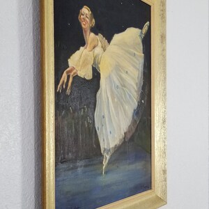 May include: A framed painting of a ballerina in a white tutu with blue accents, dancing against a dark background with stars. The painting is signed "Helen Bradley Baker" in the bottom right corner.