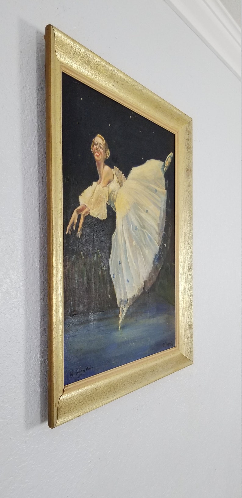 May include: A framed painting of a ballerina in a white tutu with blue accents, dancing against a dark background with stars. The painting is signed "Helen Bradley Baker" in the bottom right corner.