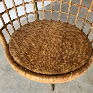 May include: A brown wicker chair with a woven seat and a metal base.