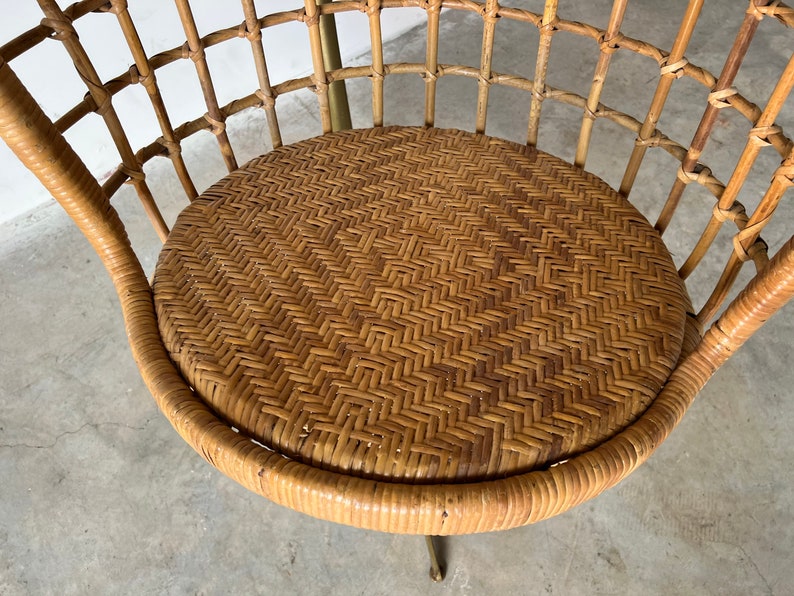 May include: A brown wicker chair with a woven seat and a metal base.