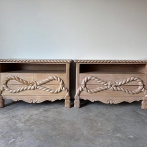 May include: Two matching wooden nightstands with a light finish. Each nightstand features a rope-like design on the front, with a shelf and two drawers. The nightstands have decorative legs and a detailed top edge.