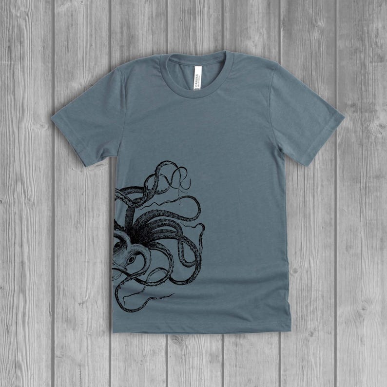 A dusty slate blue women's short-sleeve t-shirt with a black side octopus with tentacles print on the front.