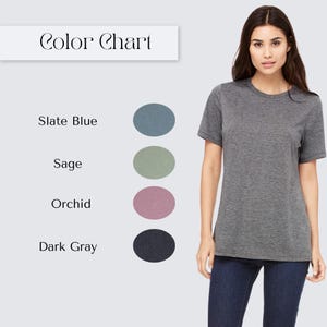 Women's short-sleeve t-shirt color chart showing dusty light mauve, orchid pink, slate teal blue, dusty sage green, and dark charcoal gray. All colors are a heather material.