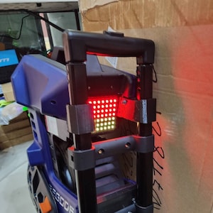 May include: A blue electric unicycle with a black handle and a red LED light. The unicycle has a black tire and a black and orange fender. The word "EGODE" is printed on the side of the unicycle.