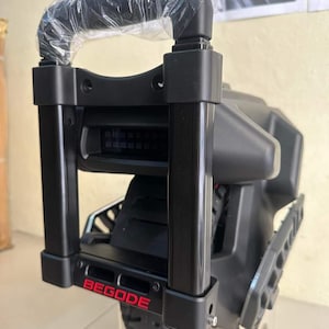 May include: A black electric unicycle with a black handle bar and a red "BEGOODE" logo. The unicycle has a large black tire and a black plastic body.