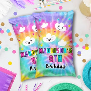 May include: Two party favor bags with a tie-dye design in shades of purple, yellow, and green. The bags feature cartoon clouds and the text "Maddi Maddison's 9th Birthday!" in bright colors. Confetti and party supplies surround the bags.