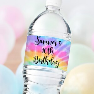 May include: Water bottle label with a tie-dye pattern in pink, blue, yellow, and green. The label has black text that says "Summer's 10th Birthday".