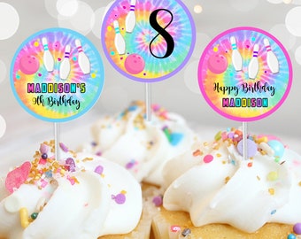 May include: Three round cupcake toppers with a tie-dye background. The toppers feature bowling pins, a bowling ball, and the text "Happy Birthday Maddison" and "Maddison's 9th Birthday".
