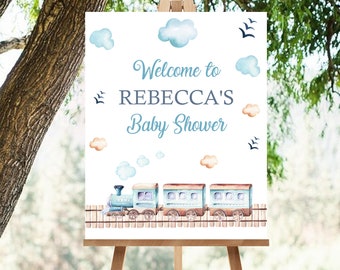 May include: Welcome to Rebecca's Baby Shower sign with a blue train and clouds on a white background.