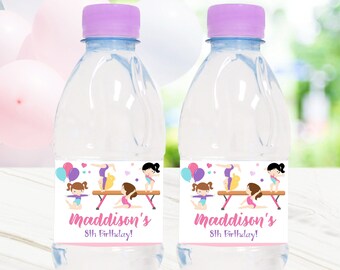 May include: Two clear plastic water bottles with purple lids and personalized labels. The labels feature a pink and purple gymnastics theme with the text "Maddison's 8th Birthday!"