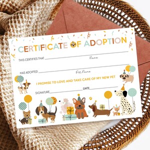 May include: A printable certificate of adoption for a pet. The certificate has a colorful design with dogs wearing party hats and balloons. The text reads "Certificate of Adoption" and includes spaces for the adopter's name, the pet's name, the date, and a signature.