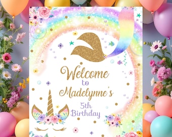 Pode incluir: Um letreiro de festa de aniversário com um design de unicórnio. O letreiro diz "Welcome to Madelynne's 5th Birthday" com um arco-íris, glitter dourado e elementos florais. Balões e flores circundam o letreiro.