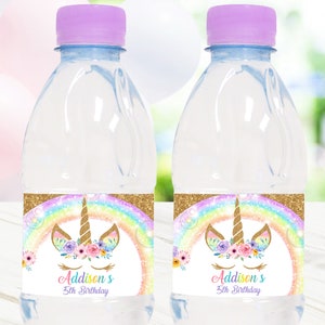 May include: Two clear water bottles with purple caps. Each bottle has a label featuring a unicorn design with a rainbow, flowers, and the text "Addison's 5th Birthday."