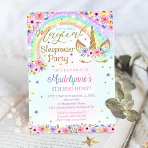 May include: A pastel blue invitation with a rainbow and a unicorn head with a floral crown. The text reads "Join us for a Magical Sleepover Party. To Celebrate Madelynne's 8th Birthday! Saturday September 21, 20XX 2PM to 5PM At Madelynne's House 2233 Unicorn Parade, Rainbow Hills RSVP by September 15 Cassandra 0400 000 000 Don't forget your pillow!"