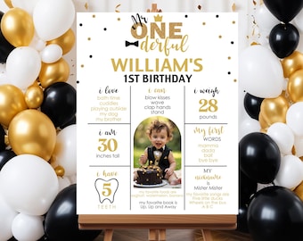 May include: A black and white printable first birthday sign with gold accents. The sign features a photo of a baby boy, along with details about his first year, including his weight, height, and favorite foods. The text on the sign reads "Mr. One Derful William's 1st Birthday".