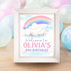 Könnte beinhalten: Ein weiß gerahmtes Schild mit einer Regenbogen- und Wolkenillustration. Der Text auf dem Schild lautet "Willkommen zu Olivia's 9th Birthday".