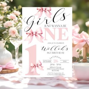 May include: A white invitation card with pink accents for a first birthday. The text reads "Girls Just Wanna Be One" with decorative pink bows. The invitation includes the date, time, and location for the party.