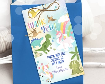Peut inclure: Une étiquette de remerciement colorée avec une licorne, des dinosaures et un arc-en-ciel. L'étiquette dit "Merci !" et "Merci d'être venu à ma fête ! Avec amour, Madelynne".