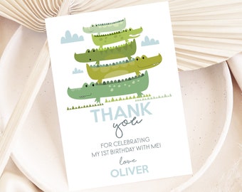 May include: Thank you card with a stack of four green alligators with white spots. The card says "Thank you" in blue and green letters and "For celebrating my 1st birthday with me! Love Oliver".