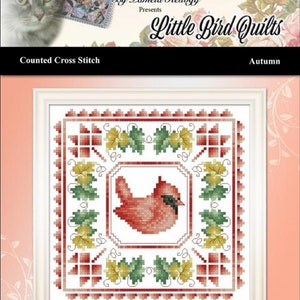 May include: Counted cross stitch pattern featuring a red cardinal bird surrounded by green and yellow leaves. The pattern is titled "Autumn" and is part of the "Little Bird Quilts" collection by Kitty Me Designs.
