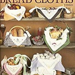 May include: A book cover with the title "Holiday Bread Cloths" and a picture of various baskets with bread and cloths. The book is from Leisure Arts and is leaflet number 462.