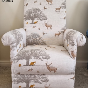 May include: High-backed armchair with a woodland animal print. The fabric design includes deer, foxes, rabbits, and trees in grey and brown tones. The chair has wooden legs. Text on the chair reads "Fryetts Tatton Animals".