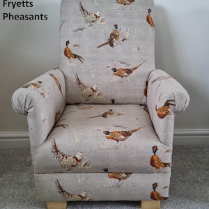 May include: Upholstered armchair with a light grey fabric featuring a pheasant pattern. The chair has a high back, rolled arms, and wooden legs. The text "Fryetts Pheasants" is visible on the upper left.