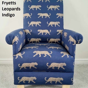 May include: An indigo blue armchair featuring a repeating pattern of tan leopards. The chair has a high back, rolled arms, and rests on four wooden legs. The text "Fryetts Leopards Indigo" is visible on the left side.