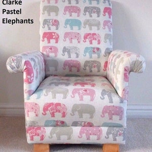 Może przedstawiać: Mały fotel z powtarzającym się wzorem pastelowych słoni w kolorze różowym, szarym i niebieskim na białym tle. Krzesło ma drewniane nogi i tekst "Clarke Pastel Elephants" po lewej stronie u góry.