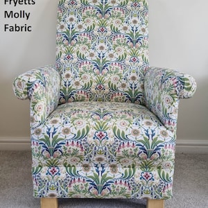 May include: An armchair upholstered in Fryetts Molly fabric featuring a repeating botanical pattern of green leaves, blue stems, and pink and white flowers. The chair has a high back, rolled arms, and light-colored wooden block feet.
