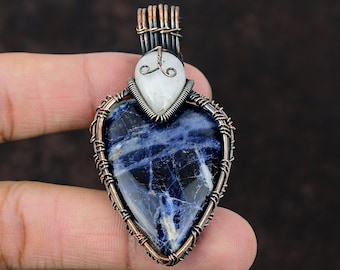 May include: A copper wire wrapped pendant featuring a blue and white heart-shaped gemstone. The pendant has a smaller white gemstone at the top.