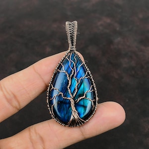 May include: A teardrop-shaped pendant with a copper wire tree design, featuring a blue labradorite gemstone.